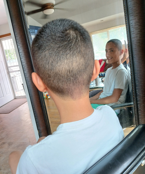 A young boy looking at himself in a mirror