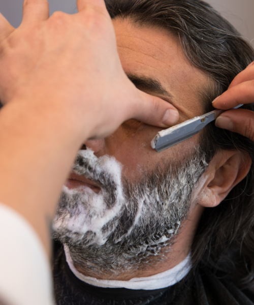 A man getting his hair cut by a barber