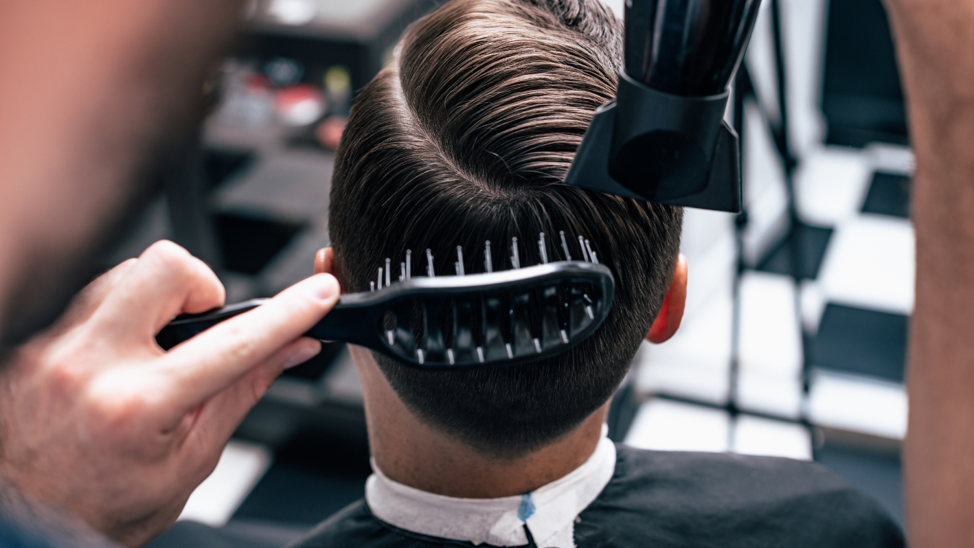 A man getting his hair cut by a hair stylist