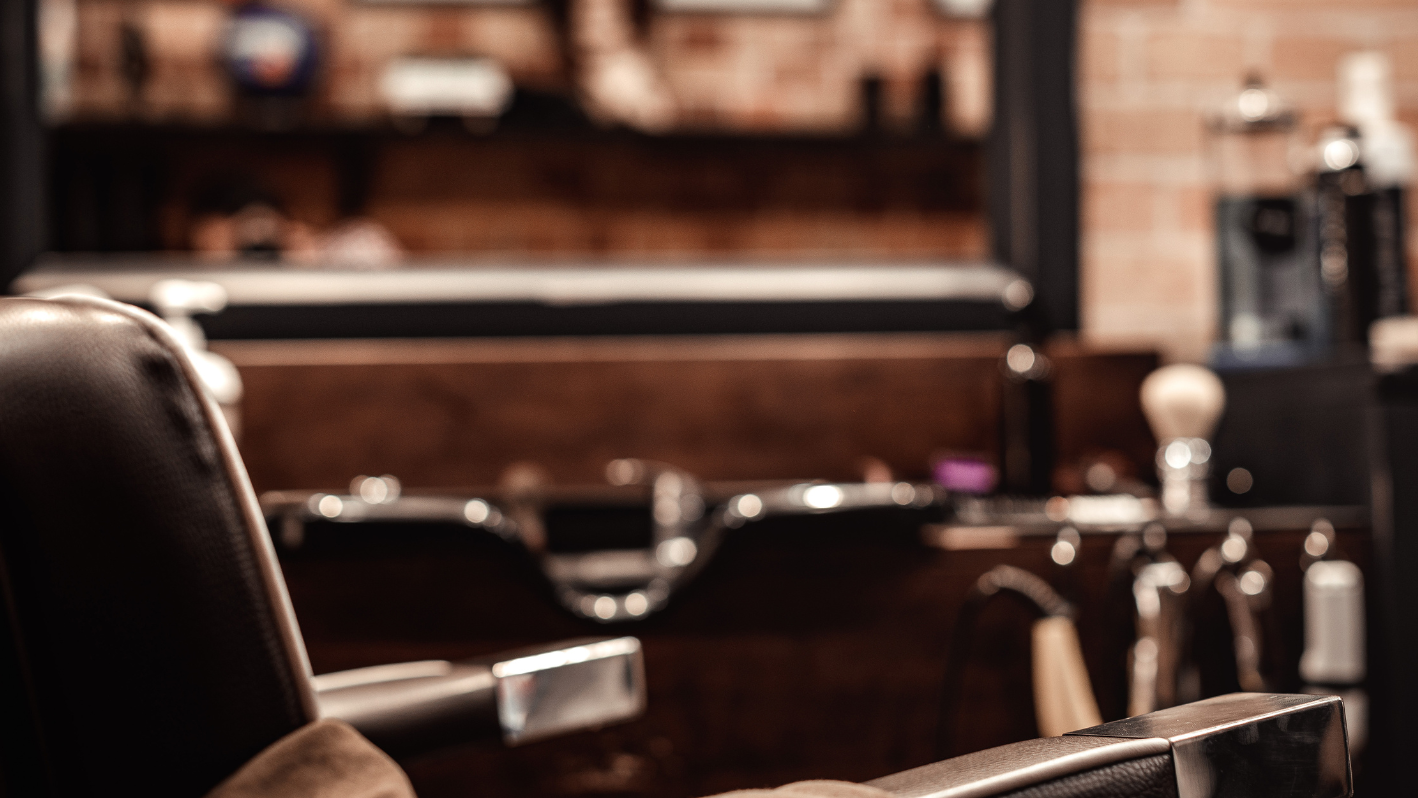 A barber chair in front of a brick wall